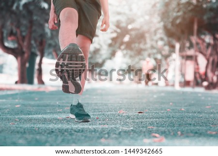 run jogging exercise uplift leg and foot for health lose weight concept on track rubber public park. Vintage tone