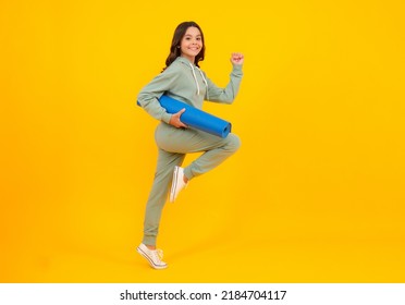 Run And Jump. Girl Teenager In Tracksuit. Happy Cute Child In A Yellow Sports Suit On A Yellow Background. Sportswear Advertising Concept.