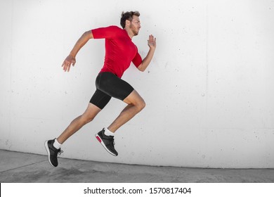 Run Race Athlete Running Man Sprinting Fast Profile Sideways Against White Wall Outdoor Background. Male Runner Training Glutes And Legs Muscles Healthy Active Lifestyle.