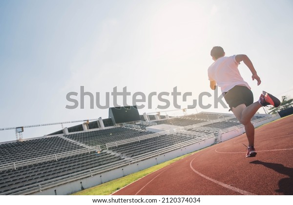The runer runs on a\
red rubber running track, starting off using the starting block.\
Sports.Sprinter Leave the default block to track work. Young m\
running on the road.
