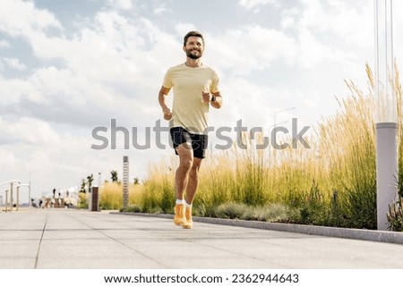 Runner active interval training and warm-up. Motivation and an active lifestyle in the city. A young male fitness trainer in comfortable outdoor sportswear.