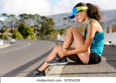 Runner With Ankle Injury Holds Foot To Reduce Pain. Running Problem For Athlete Training Outdoors