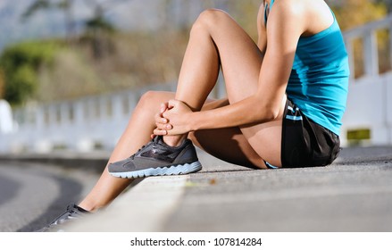 runner with ankle injury holds foot to reduce pain. running problem for athlete training outdoors