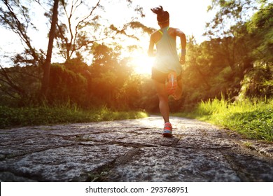 Runner athlete running on forest trail. woman fitness jogging workout wellness concept.  - Powered by Shutterstock