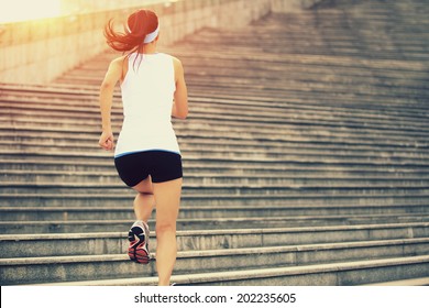 Runner athlete running on stairs. woman fitness jogging workout wellness concept.  - Powered by Shutterstock