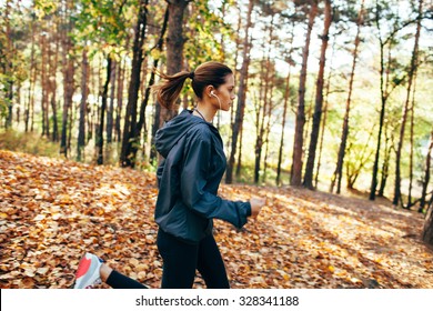 Runner Caucasian Woman Wearing Dark Gray Jacket Jogging In Autumn Park, Right Side View