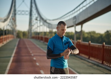 Runner checking smartwatch controlling pulsations after exercise
