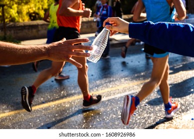 Runner collects a bottle of water to hydrate during a workout. - Powered by Shutterstock