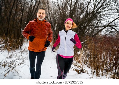 A Runner couple jogging in park in warm winter sports clothing - Powered by Shutterstock