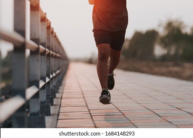 Runner feet running on road closeup on shoe. MAN fitness sunrise jog workout welness concept. - Shutterstock ID 1684148293