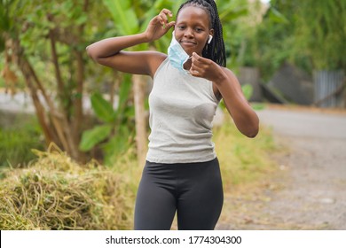 runner girl lifestyle during post quarantine new normal times - young attractive and fit black afro American woman adjusting face mask before running workout at countryside road - Powered by Shutterstock