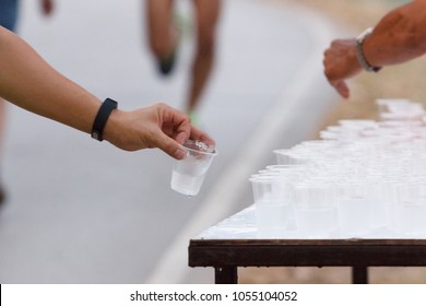 Runner Hand Take A Water Cup In A Marathon Race.Running Outdoor Exercise.