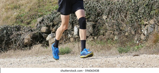 Runner Jogging During Training With The Sports And A Knee Brace On The Bad Knee