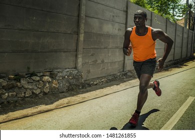 Runner Lifestyle Portrait Of Young Attractive And Fit Black African American Professional Sport Man With Athletic Body Running On City Street Pushing Hard Under Harsh Sun In Urban Background 