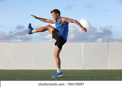 Runner man getting ready to run doing warm-up dynamic leg stretch exercises routine, Male athlete stretching lower body hamstring muscles before going running outside in summer outdoors. - Powered by Shutterstock