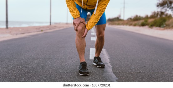 Runner Man With Knee Injury And Pain On The Road