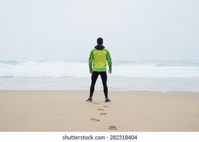 Runner Man On The Beach In A Rainy Day