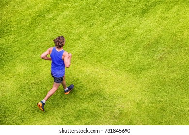 Runner Man Running Jogging On Summer Green Grass Texture Park Jogging Healthy Lifestyle. People Working Out Cardio Top View. Copy Space On Background.