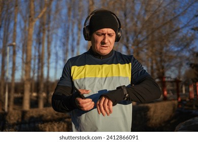 Runner man setting up his smartwatch before running with headphones - Powered by Shutterstock