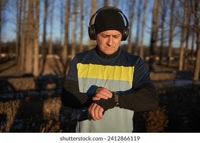 Runner man setting up his smartwatch before running with headphones - Powered by Shutterstock