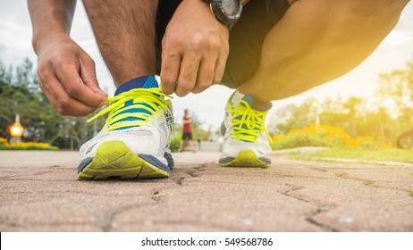 Runner Man Tying Running Shoes Laces Getting Ready For Race On Road.