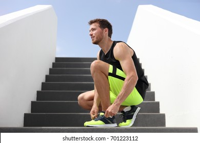 Runner man tying running shoes laces getting ready to run up the gym stairs training cardio hiit workout exercise on staircase. Acitve healthy lifestyle sport athlete, fitness motivation. - Powered by Shutterstock