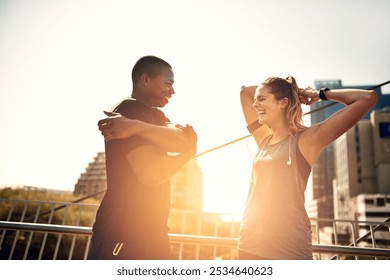 Runner, man and woman with warm up on bridge with exercise, laugh and funny joke at sunrise in city. People, couple and stretching arms in street with lens flare, fitness and workout in morning - Powered by Shutterstock