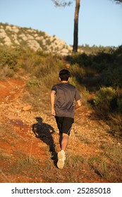 Runner moving through sunlit landscape.