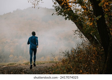 Runner Navigating Tranquil Paths Amidst Autumn's Foggy Embrace
