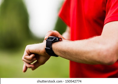 Runner on mountain trail looking at sports smart watch, checking performance or heart rate pulse trace. Sport and fitness outdoors in nature. - Powered by Shutterstock