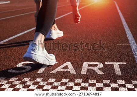 Runner is preparing to take step forward on track with word START. conveys the inspirational concept of starting a business and career path.