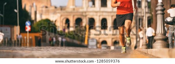 Runner running in Rome city street at\
marathon run. Banner panorama of athlete\'s legs and running shoes\
in outdoor background.