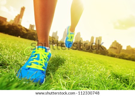 Runner - running shoes closeup of woman barefoot running shoes. Female jogging in Central Park, New York City.