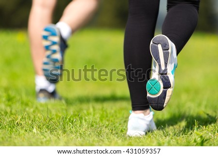 Runner - running shoes closeup of woman and man barefoot running shoes. Jogging in Park