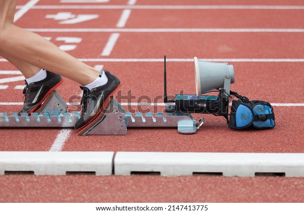 Runner starting\
from  starting block on stadium track for sprint 400 meter run\
detail on legs close up\
photography