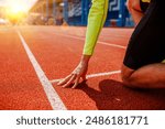 A runner is in the starting position, Rear view of a young female athlete starting the starting line in a race