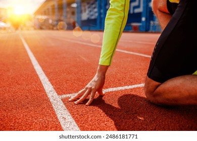 A runner is in the starting position, Rear view of a young female athlete starting the starting line in a race - Powered by Shutterstock