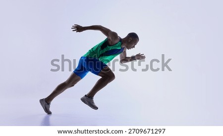 Runner stepping into low start posture before sprint. Concept of athlete preparation tutorials, sprint mechanics lessons, sports education materials, and fitness training resources.