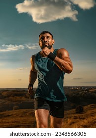Runner. Trail run. Athlete sprinter outdoor. Athletic man running on sunset wearing in the sportswear. Fitness and sport motivation. Sports concept.