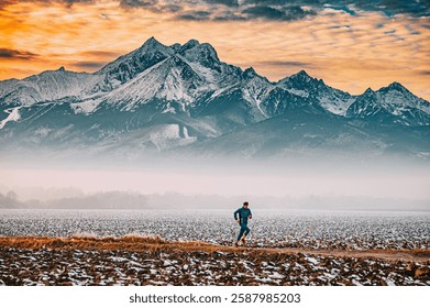 Runner train in the fields during winter season, Massive mountains in background. Orange sunset light