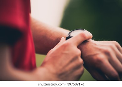 Runner Using Heart Rate Monitor Training Running, Smartwatch Checking Performance Or GPS. Man Athlete Looking At Stopwatch. Healthy Runner On Running Trail. Wearable Technology For Tracking Activity.