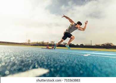 Runner using starting block to start his run on running track. Athlete starting his sprint on an all-weather running track with the help of starting block.