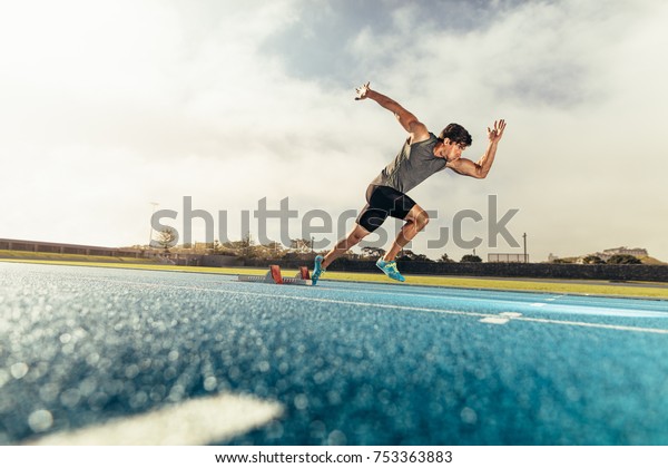 Runner using starting block to start\
his run on running track. Athlete starting his sprint on an\
all-weather running track with the help of starting\
block.