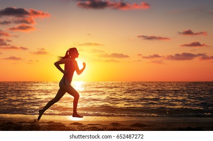 Runner Woman Running In The Beach At Sunset
