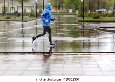 Runner Woman Running In Park In The Rain. Jogging Training For Marathon.