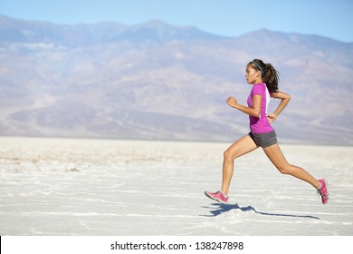 Runner Woman Running And Sprinting On Trail Run In Desert. Female Sport Fitness Athlete In High Speed Sprint In Amazing Desert Landscape Outside. Mixed Race Asian Caucasian Fit Sports Model Sprinter.