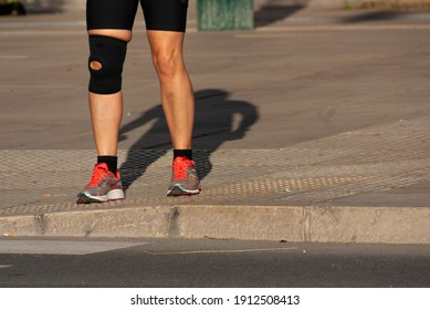 Runner Woman That Suffered A Knee Accident And Now Wears Knee Brace On The Sidewalk