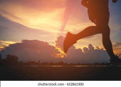 Runner's Feet, Motion Blurred Runner Closeup Shot  Runner Running At A Fast Pace Background Clouds Sky Sunlight