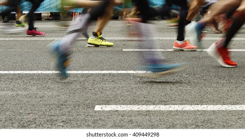 Runners Feet On The Road In Blur Motion During A Long Distance Running Event