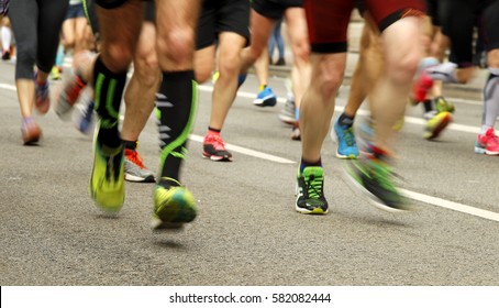 Runners feet on the road in blur motion during a long distance running event - Shutterstock ID 582082444